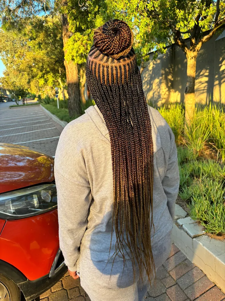 Close-up of intricate knotless braids in golden morning light